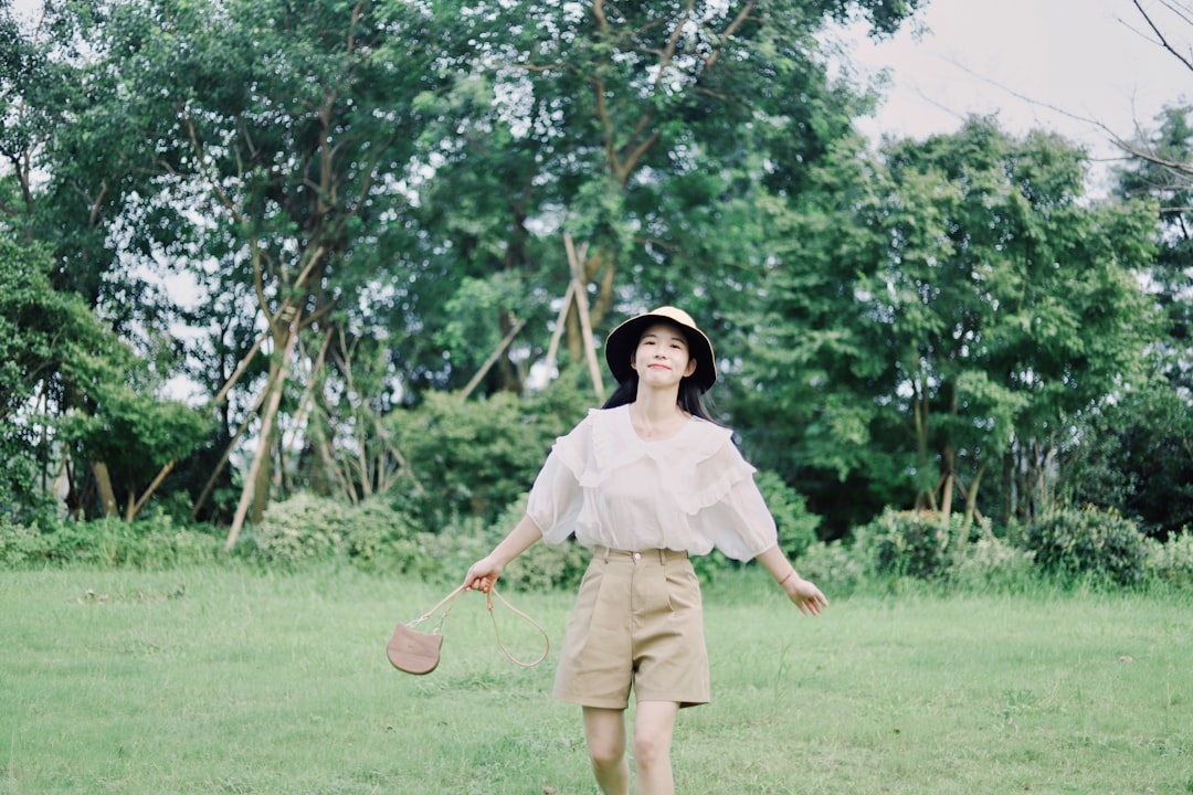 woman in white dress standing on green grass field during daytime