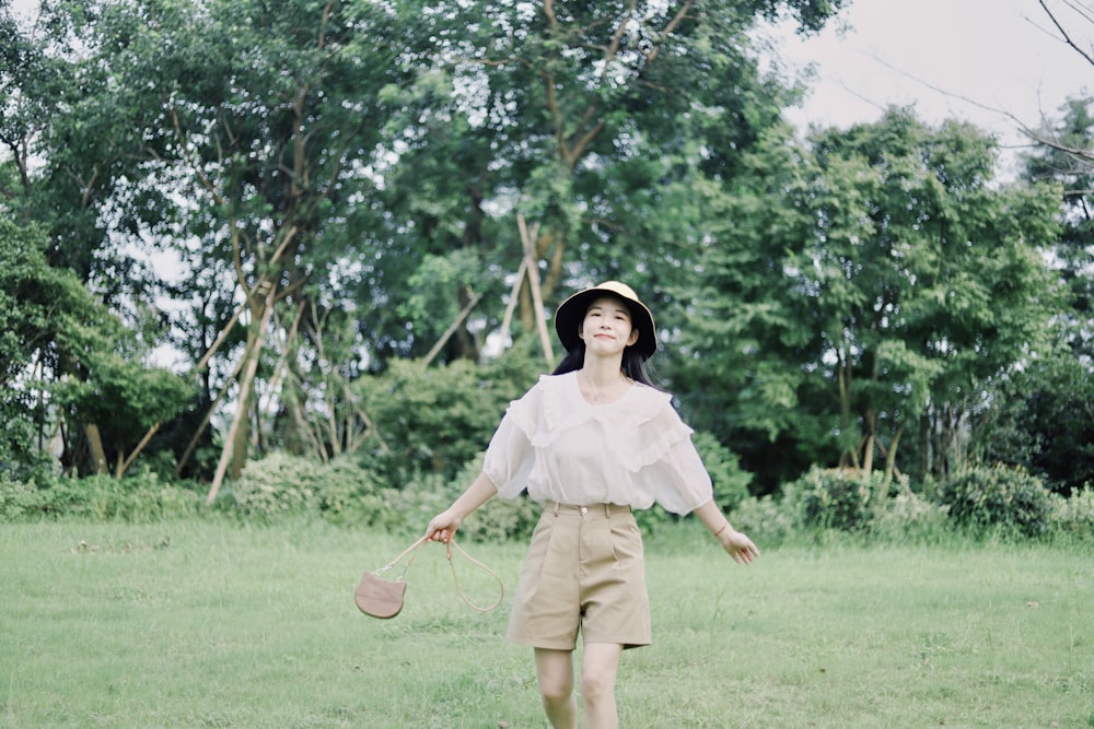 woman in white dress standing on green grass field during daytime