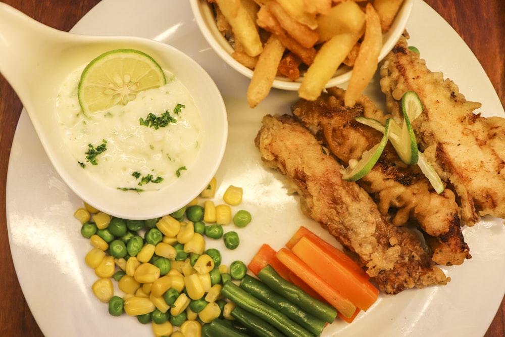 fried chicken and fries on white ceramic plate