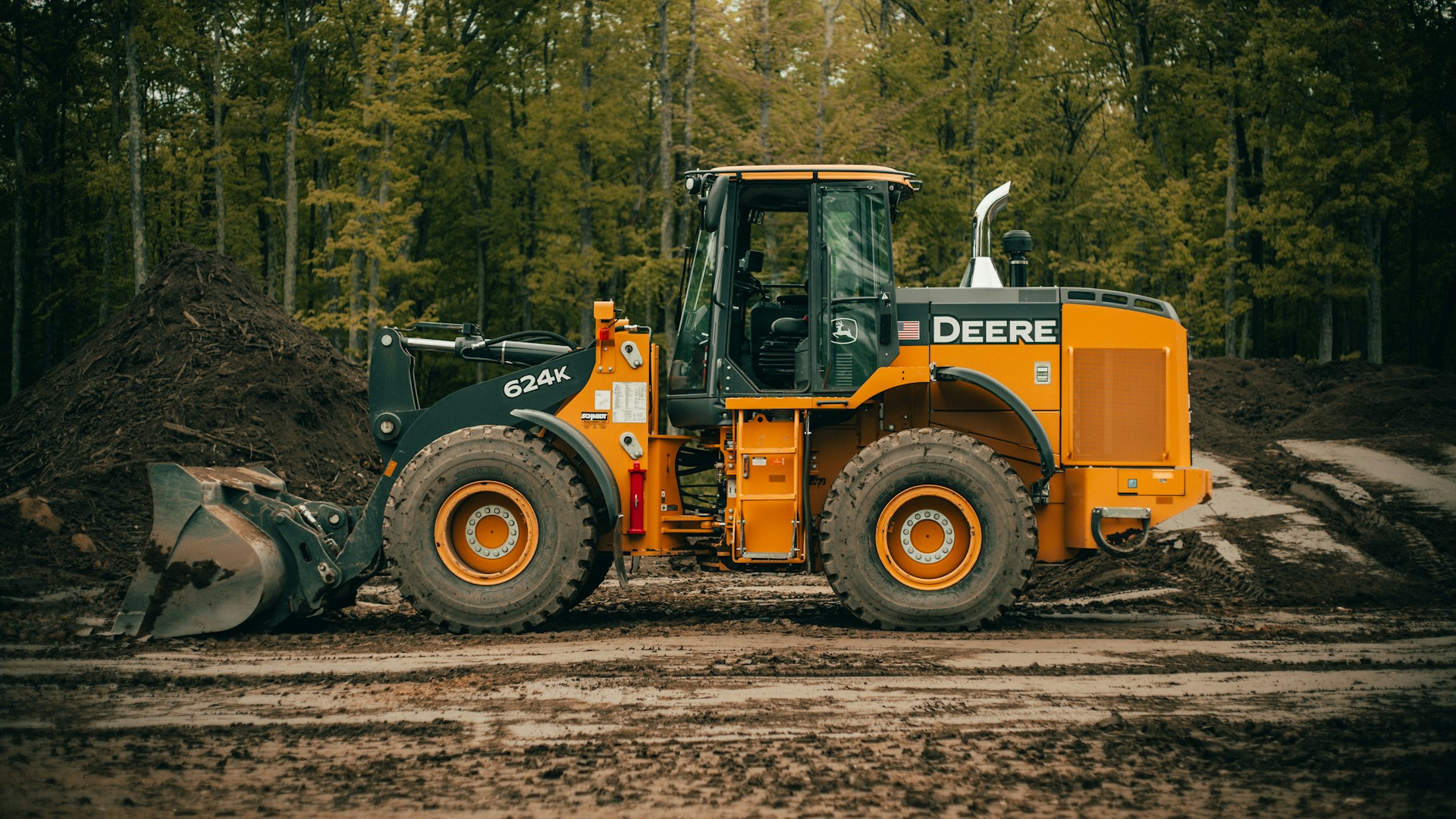 a tractor is parked in the dirt near a pile of dirt