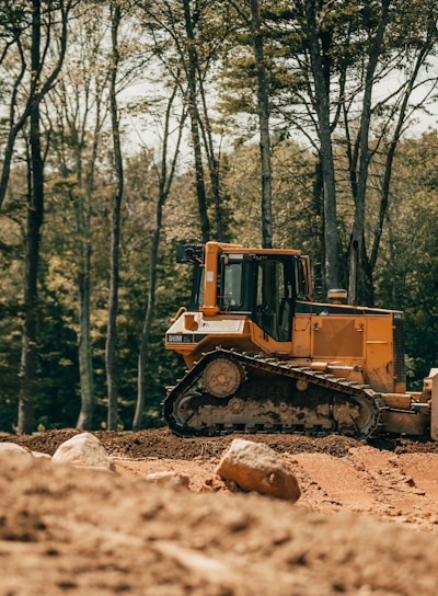 yellow and black heavy equipment on brown soil