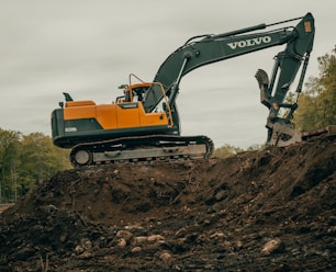 orange and white excavator on brown ground during daytime