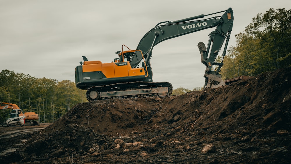 orange and white excavator on brown ground during daytime