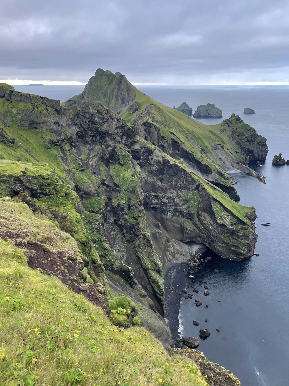 green and gray mountain beside body of water during daytime