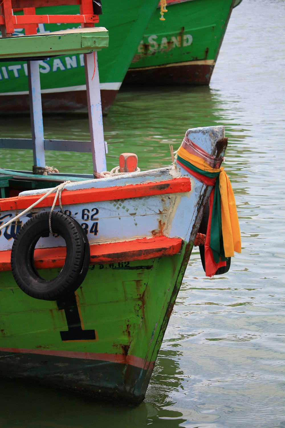 red and green boat on water during daytime