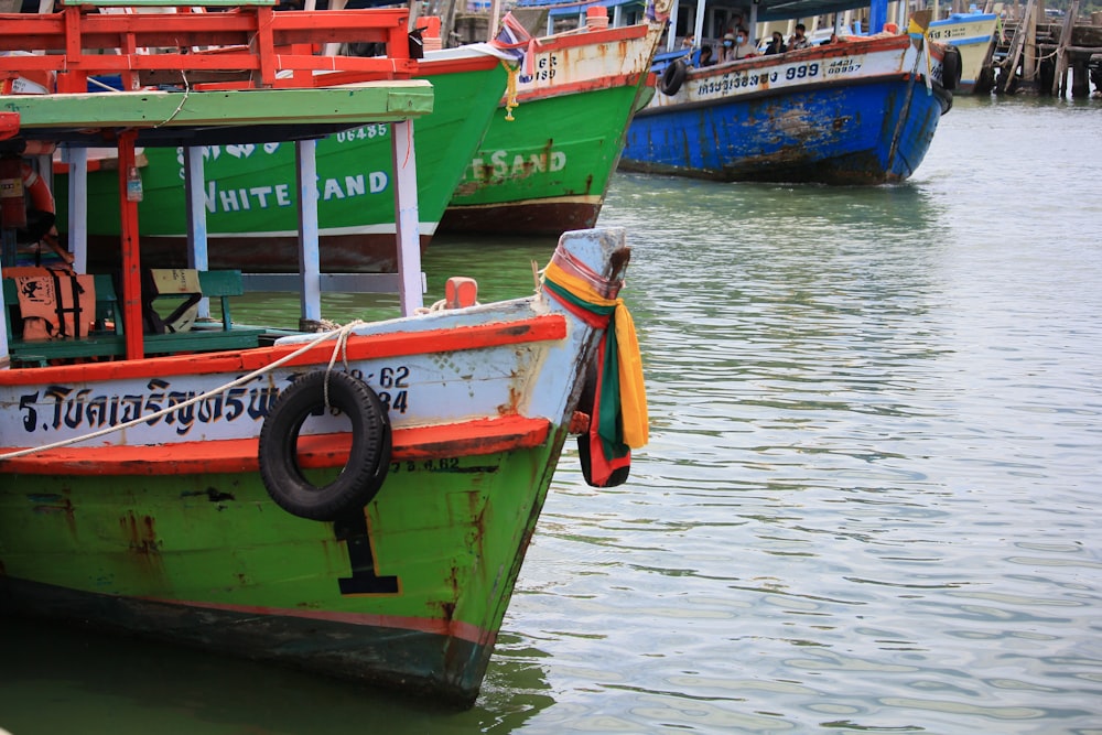 red and green boat on body of water during daytime