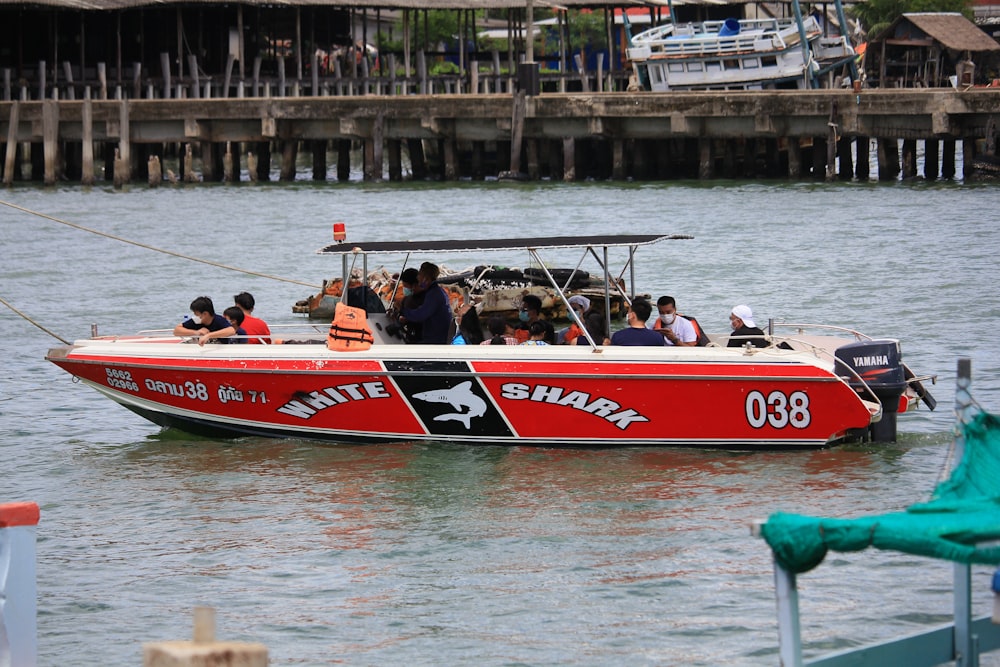 people riding red and white watercraft during daytime