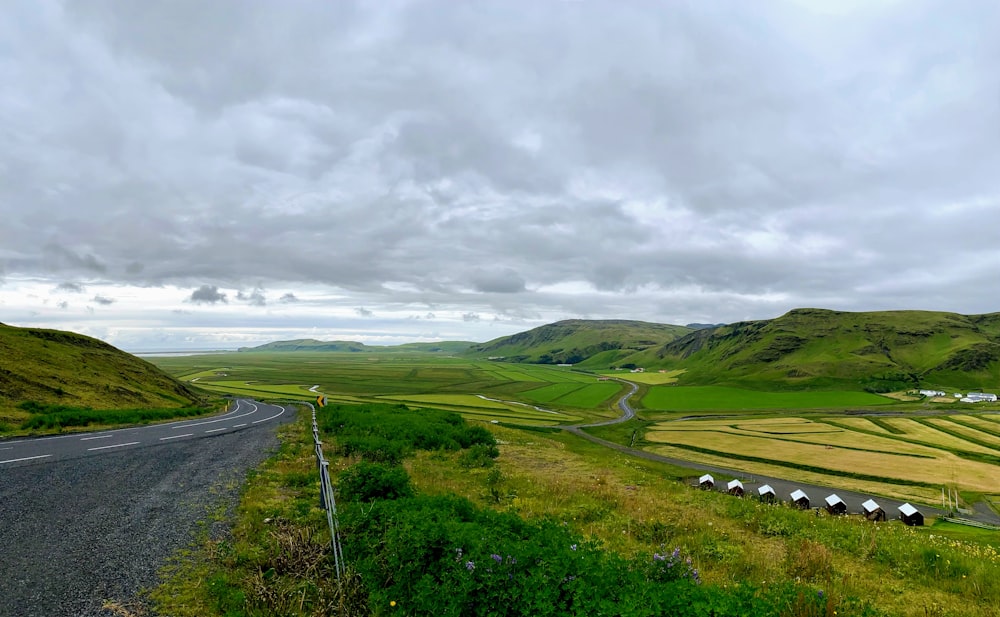 green grass field under cloudy sky during daytime