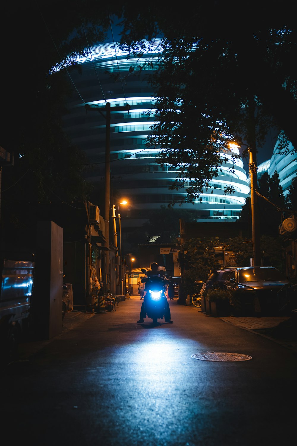 man in blue shirt riding motorcycle on road during night time