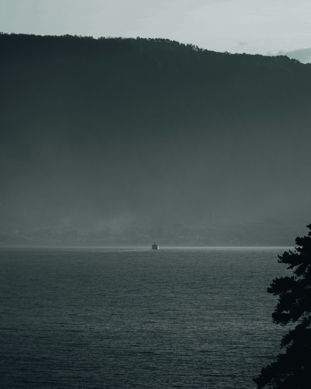 body of water near mountain during daytime