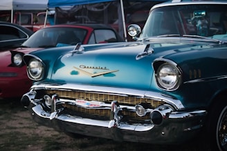 blue classic car parked on gray asphalt road during daytime