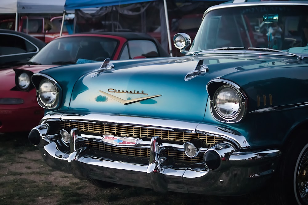 blue classic car parked on gray asphalt road during daytime