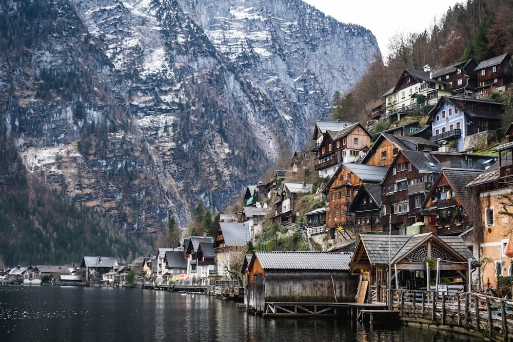 houses near body of water and mountain during daytime