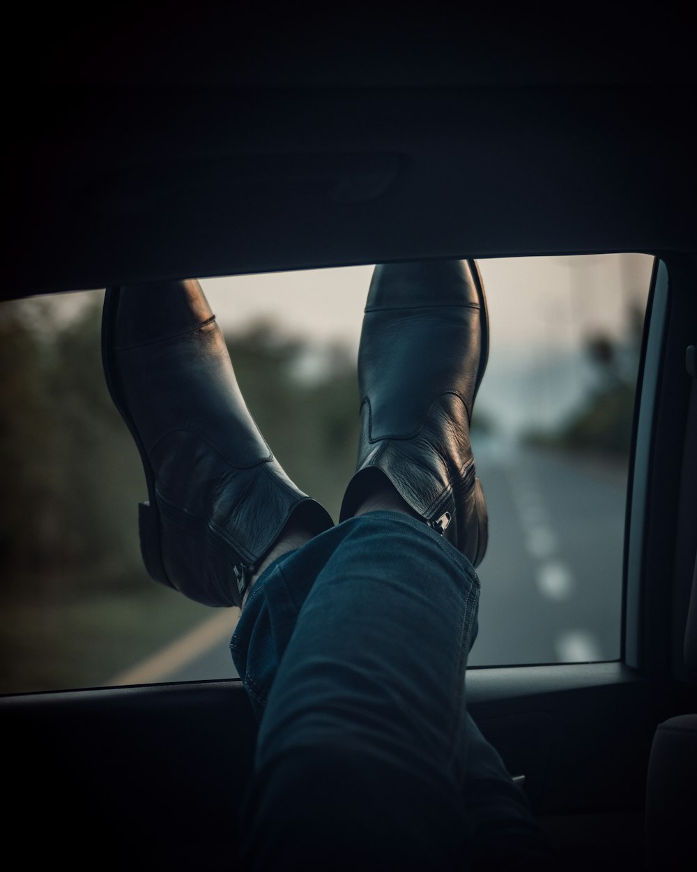 person in blue denim jeans and black leather shoes