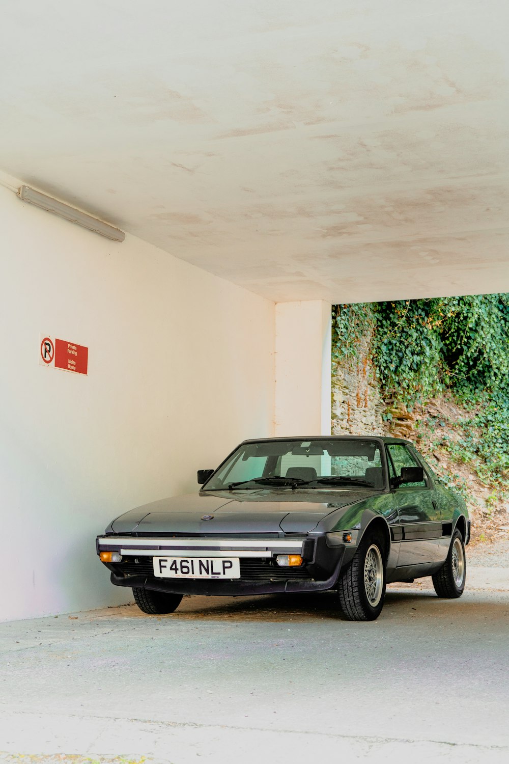 black mercedes benz coupe parked beside white wall