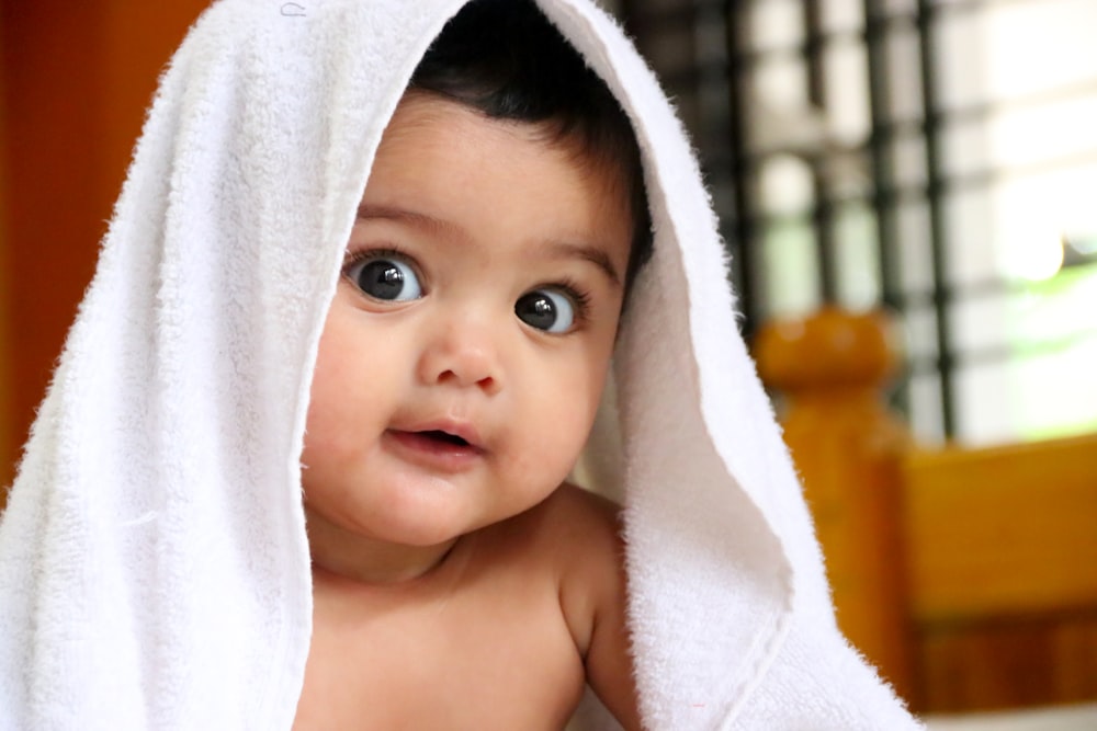 niña cubierta con toalla blanca