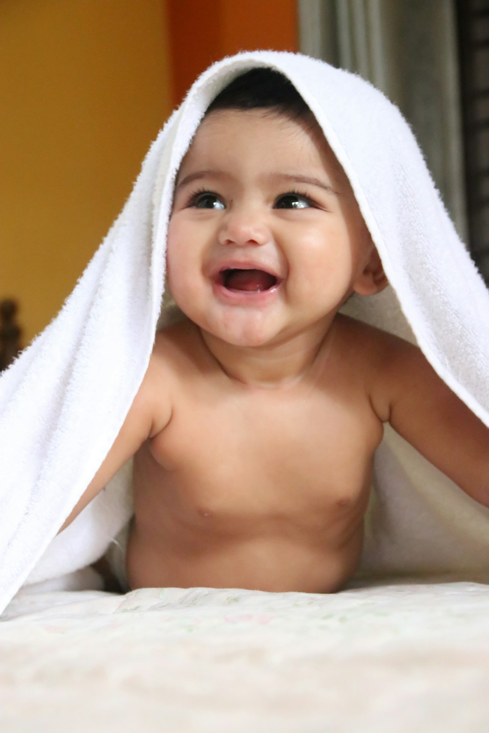 Niño en topless cubierto con toalla blanca
