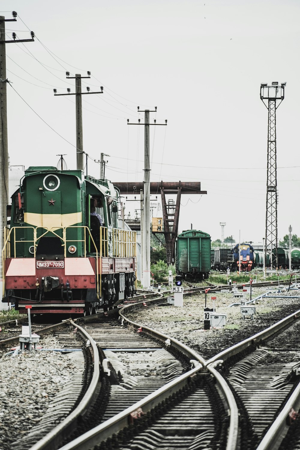 trem verde e amarelo nos trilhos ferroviários durante o dia