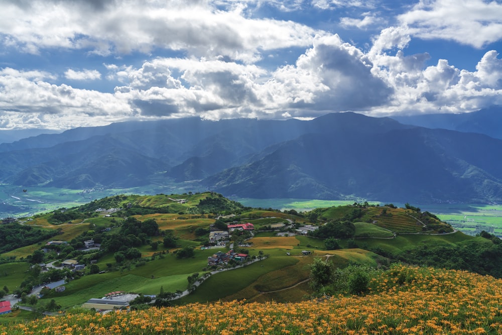 green grass field under white clouds and blue sky during daytime