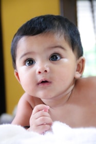 A close-up of a baby’s curious eyes during a natural light photoshoot in a cozy home setting.