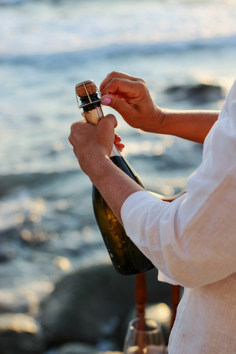 person in white long sleeve shirt holding bottle