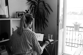 woman in striped long sleeve shirt using laptop computer