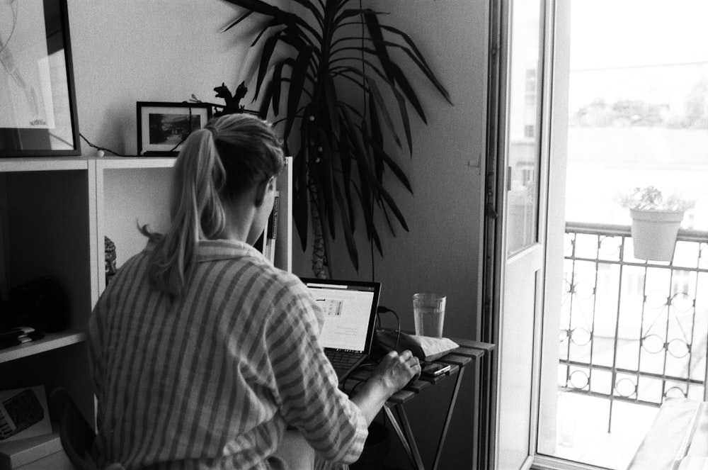 노트북 컴퓨터를 사용하는 줄무늬 긴 소매 셔츠를 입은 여자