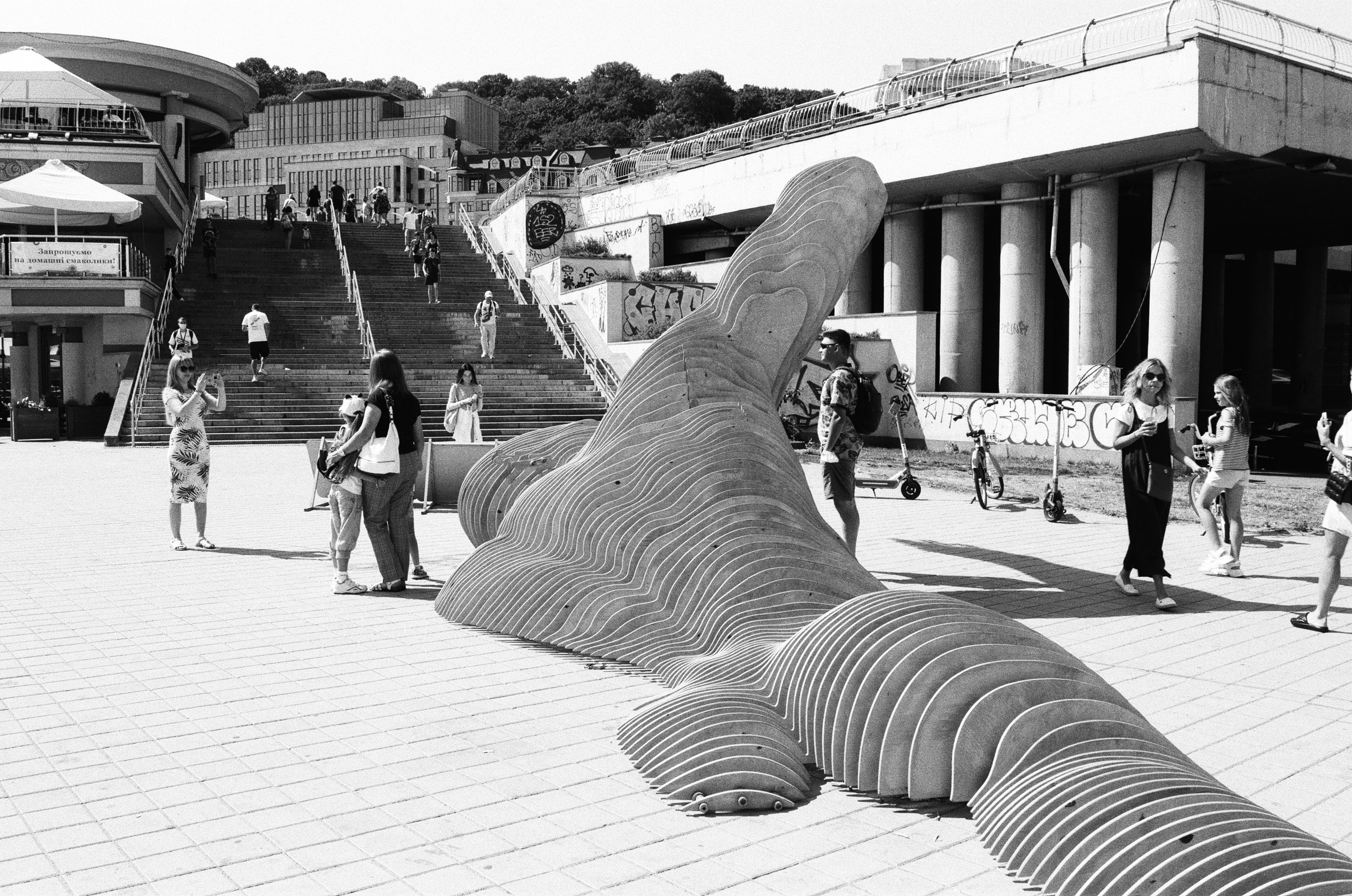 grayscale photo of persons feet on concrete floor