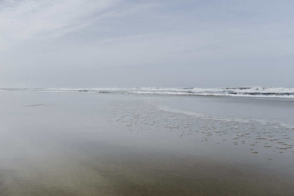 body of water under white clouds during daytime