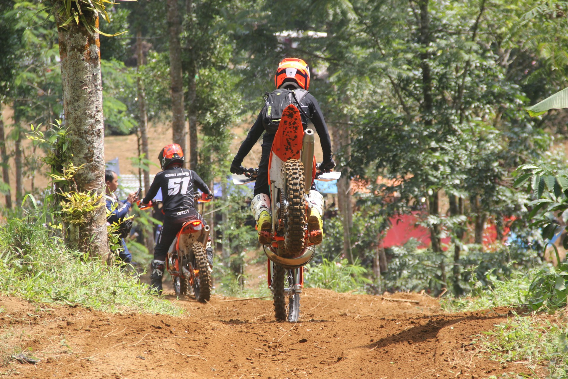 Riders navigating a winding trail surrounded by lush greenery, capturing the thrill of the ride.