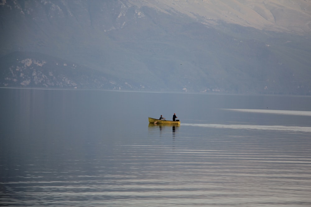 man riding on yellow kayak on body of water during daytime