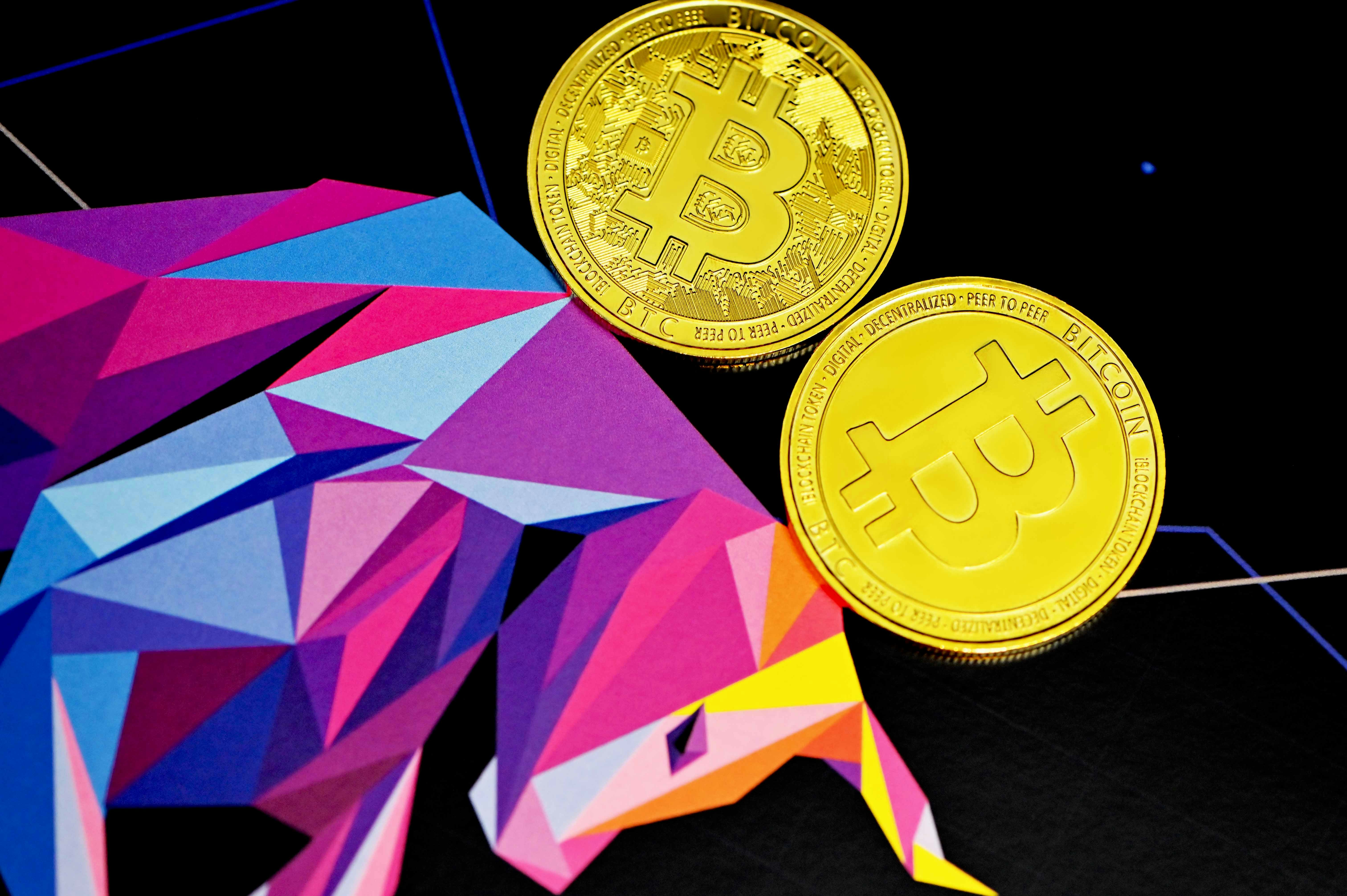 Two Bitcoins placed on top of an Executium bull
