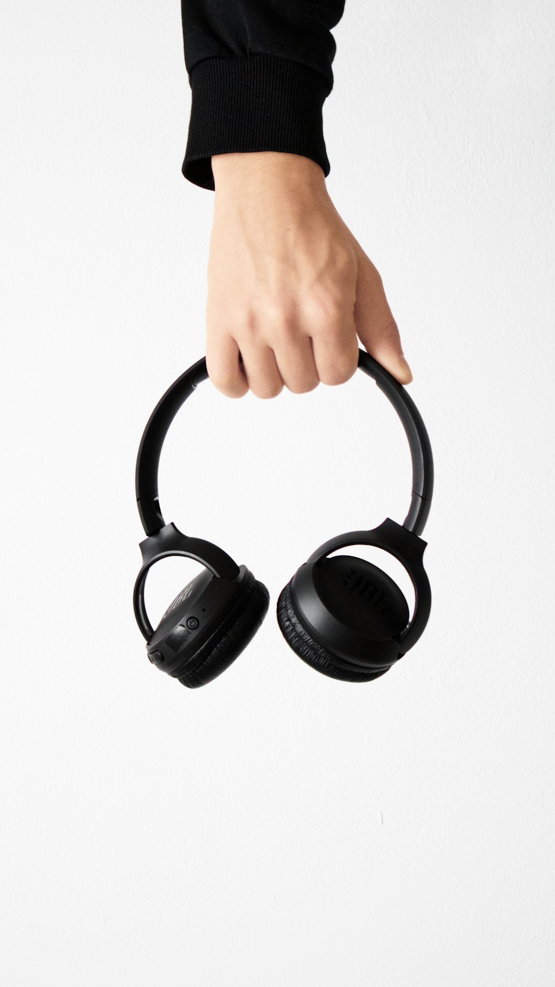 person holding black and gray wireless headphones