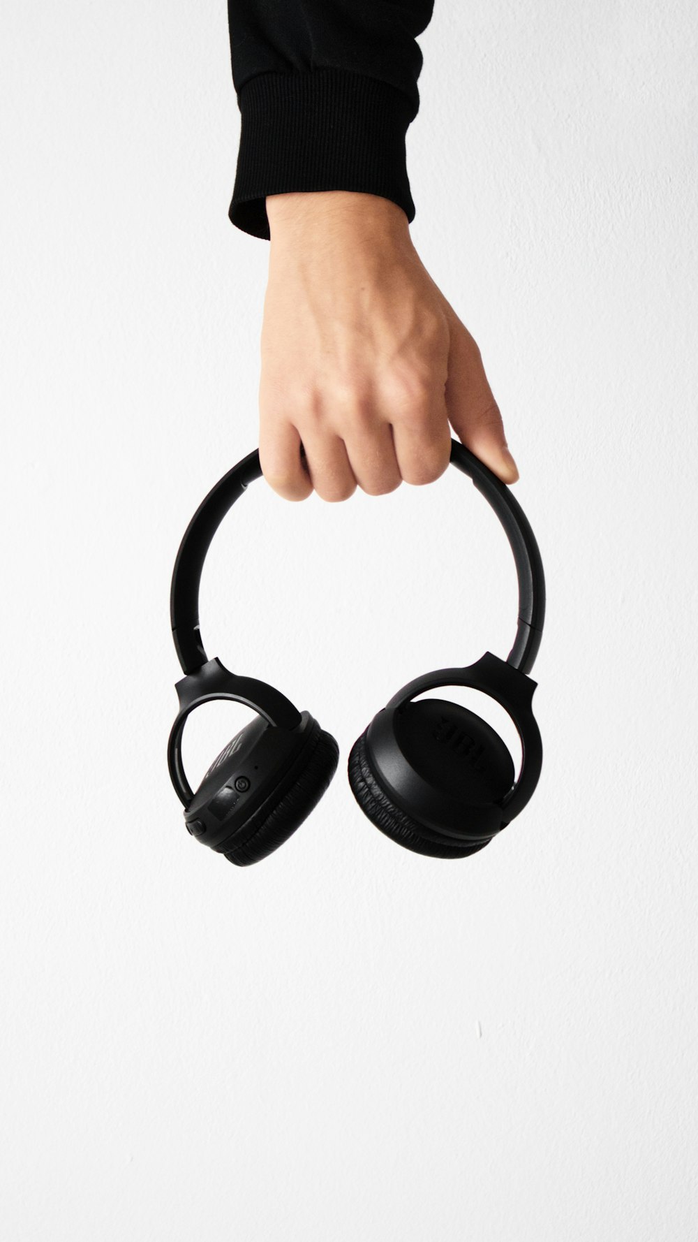 person holding black and gray wireless headphones