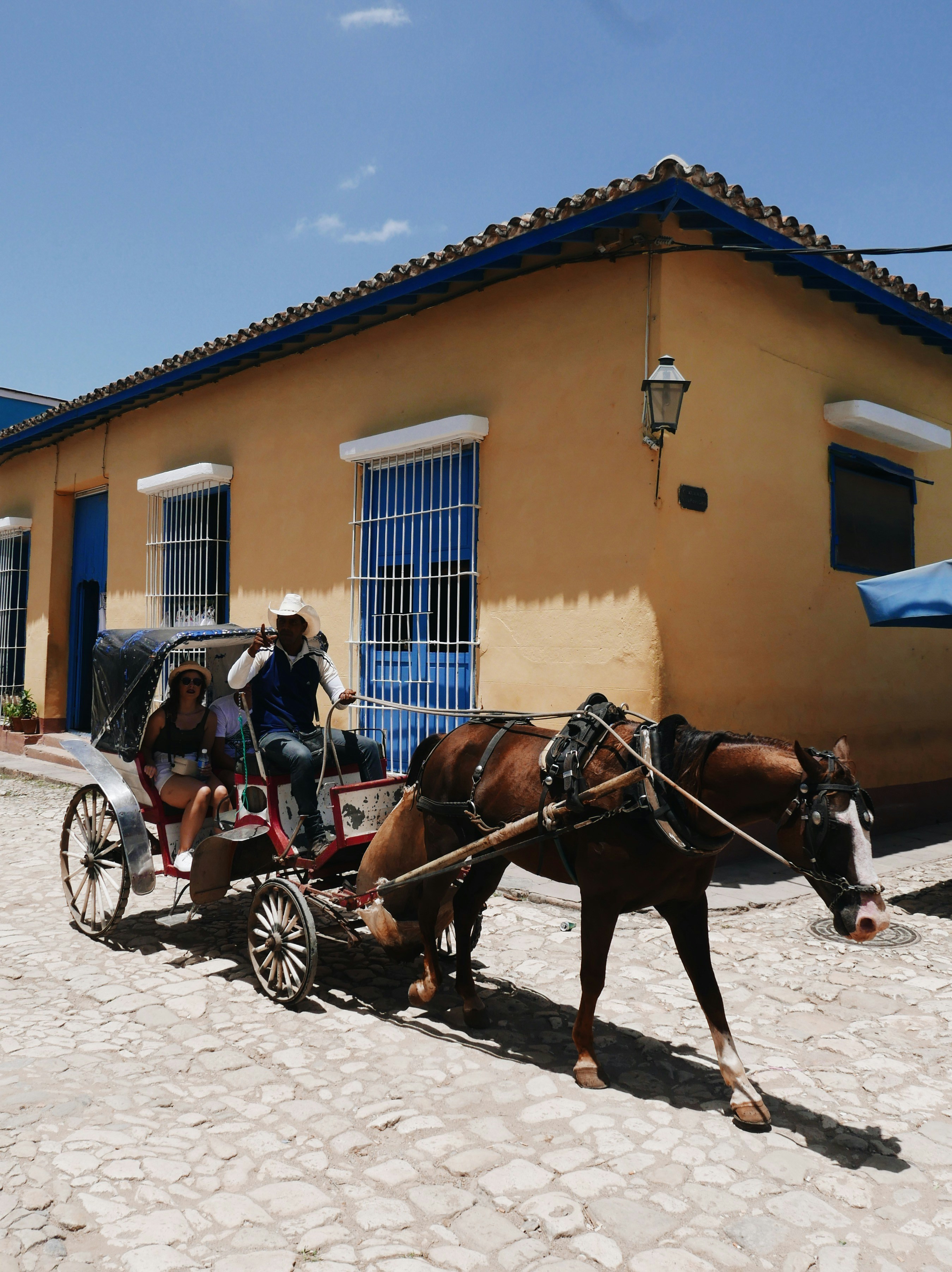 people riding horses in front of brown concrete building during daytime
