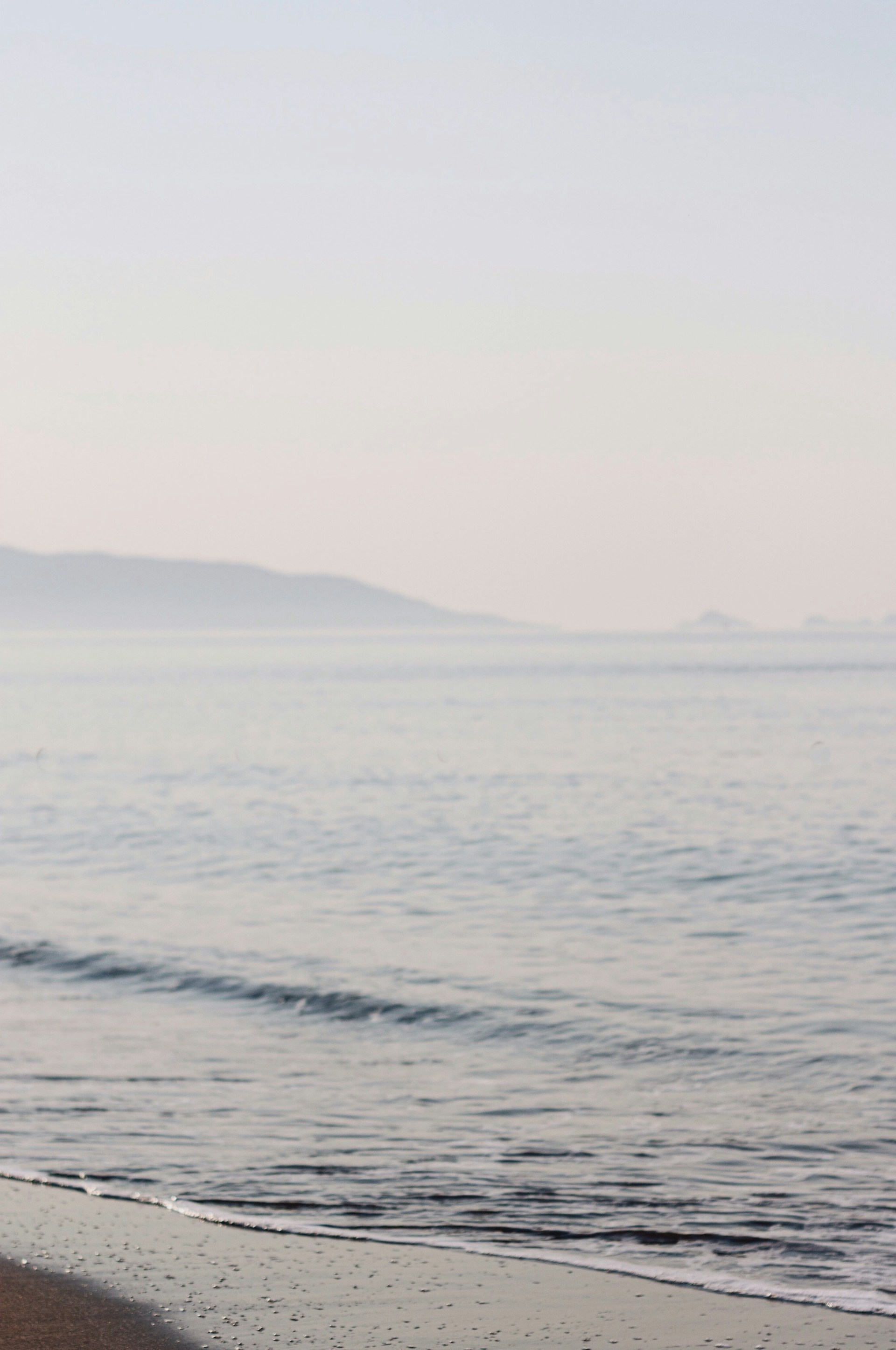 body of water near mountain during daytime
