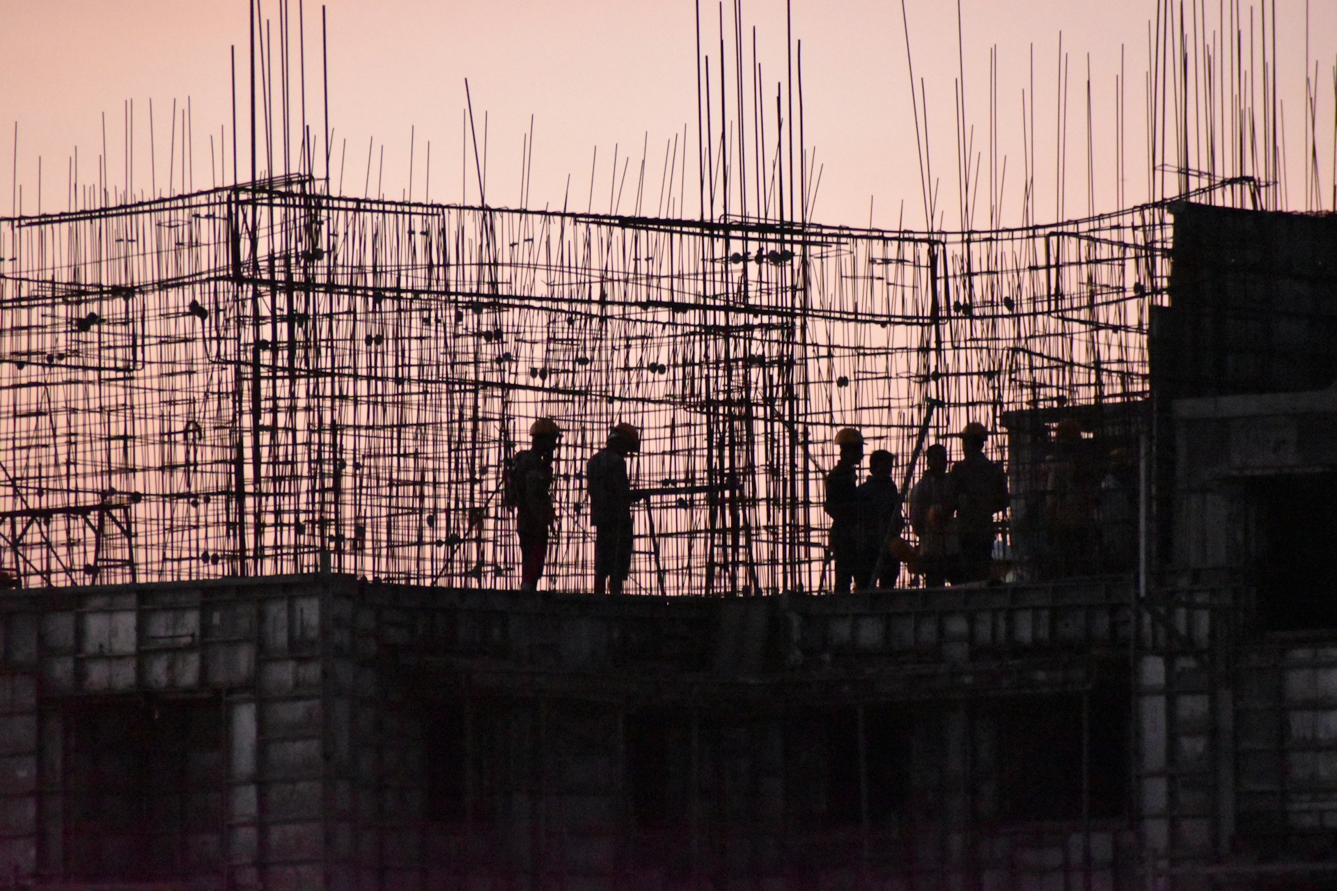 silhouette of people standing on building during sunset