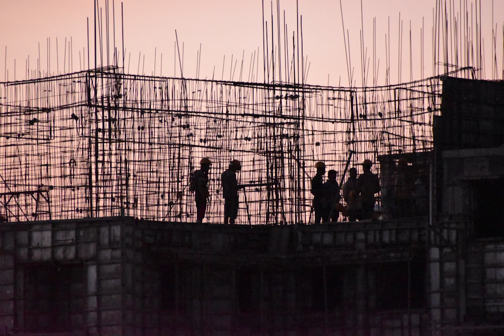 silhouette of people standing on building during sunset