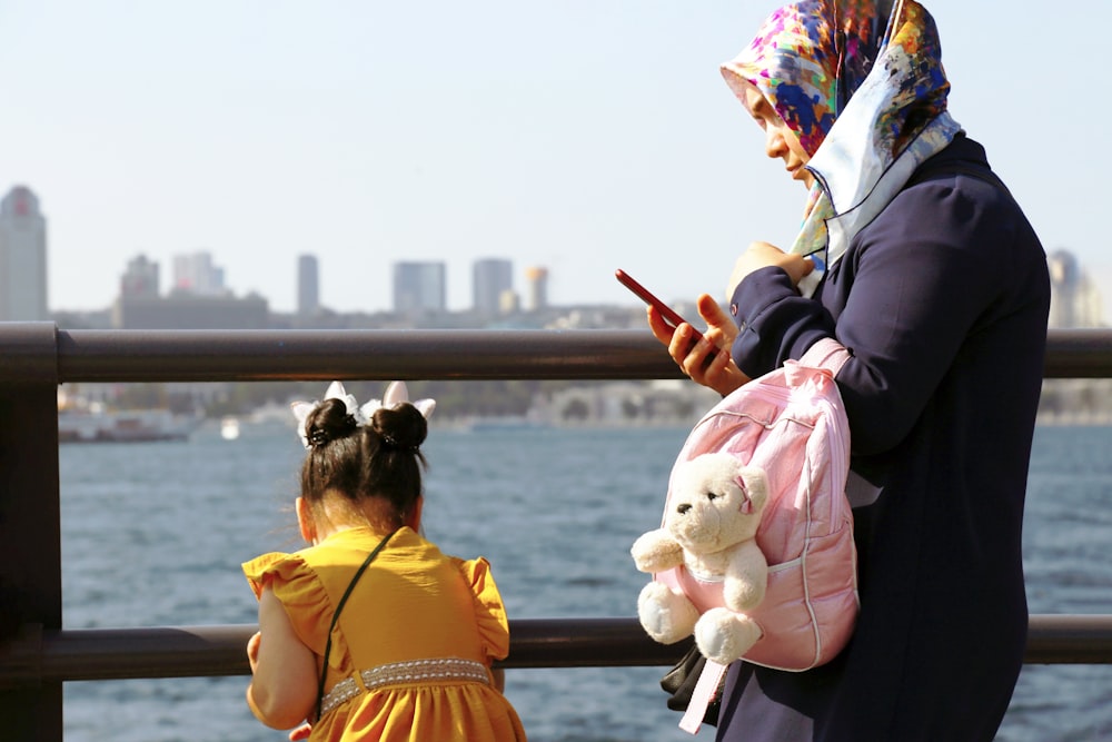 woman in black jacket holding white bear plush toy