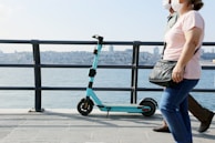 Two-person 2000w electric scooter with electric blue accents cruising along a city road.