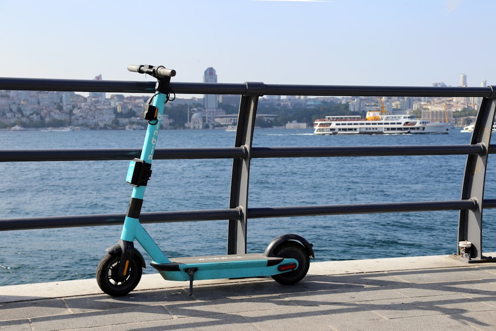 blue and black kick scooter near body of water during daytime
