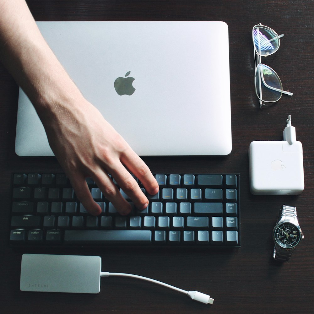 silver macbook beside white apple earpods