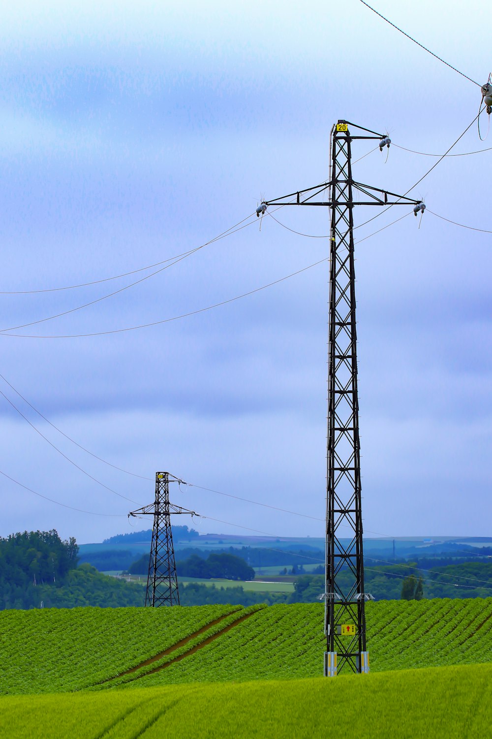 poteau électrique noir sous ciel bleu pendant la journée