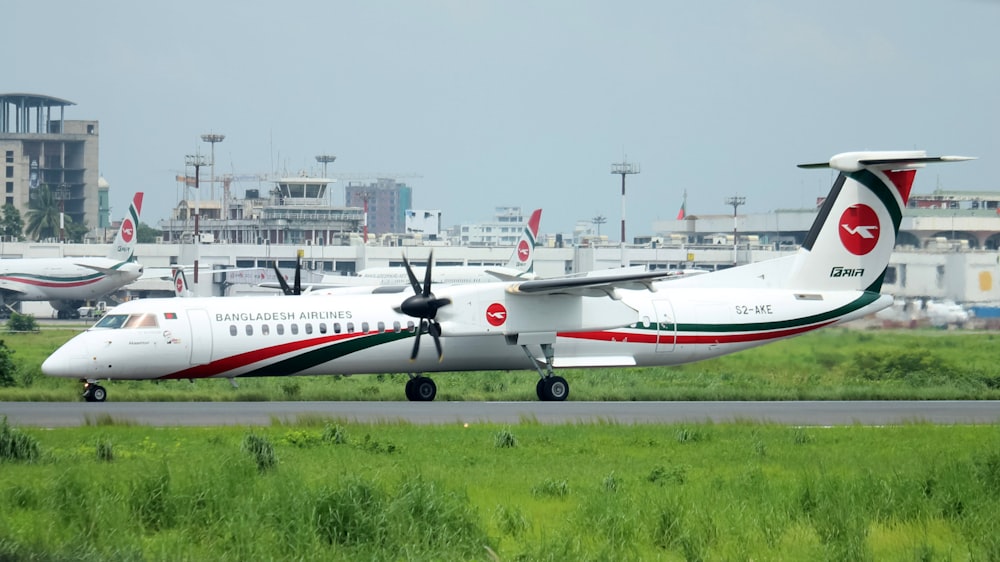 white and red passenger plane on airport during daytime