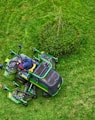 green and black ride on lawn mower on green grass field during daytime