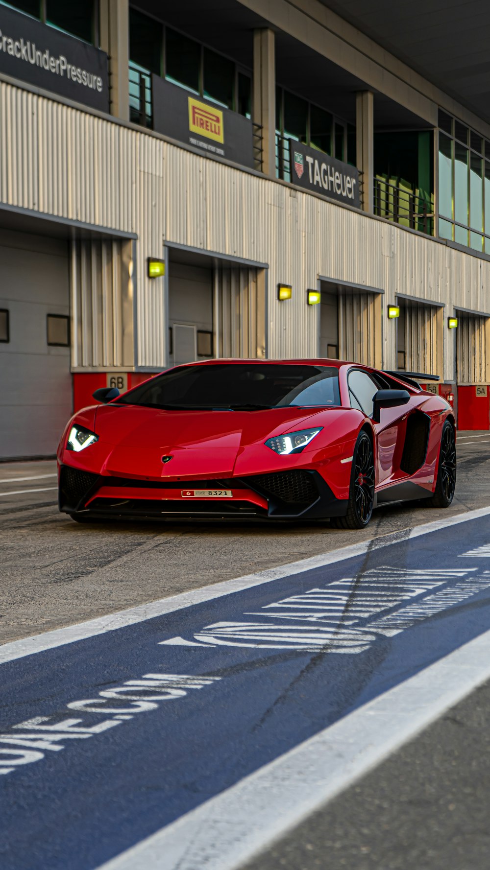 Roter Ferrari 458 Italia parkt in der Nähe des weißen Gebäudes