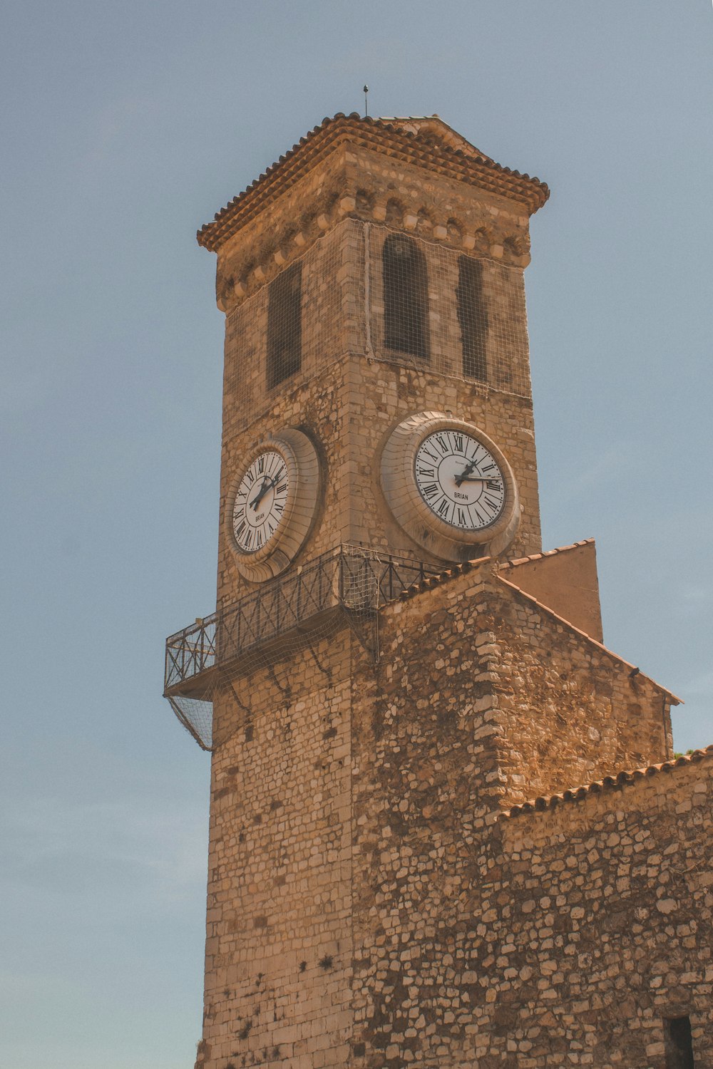 Brauner Betonturm mit analoger Uhr