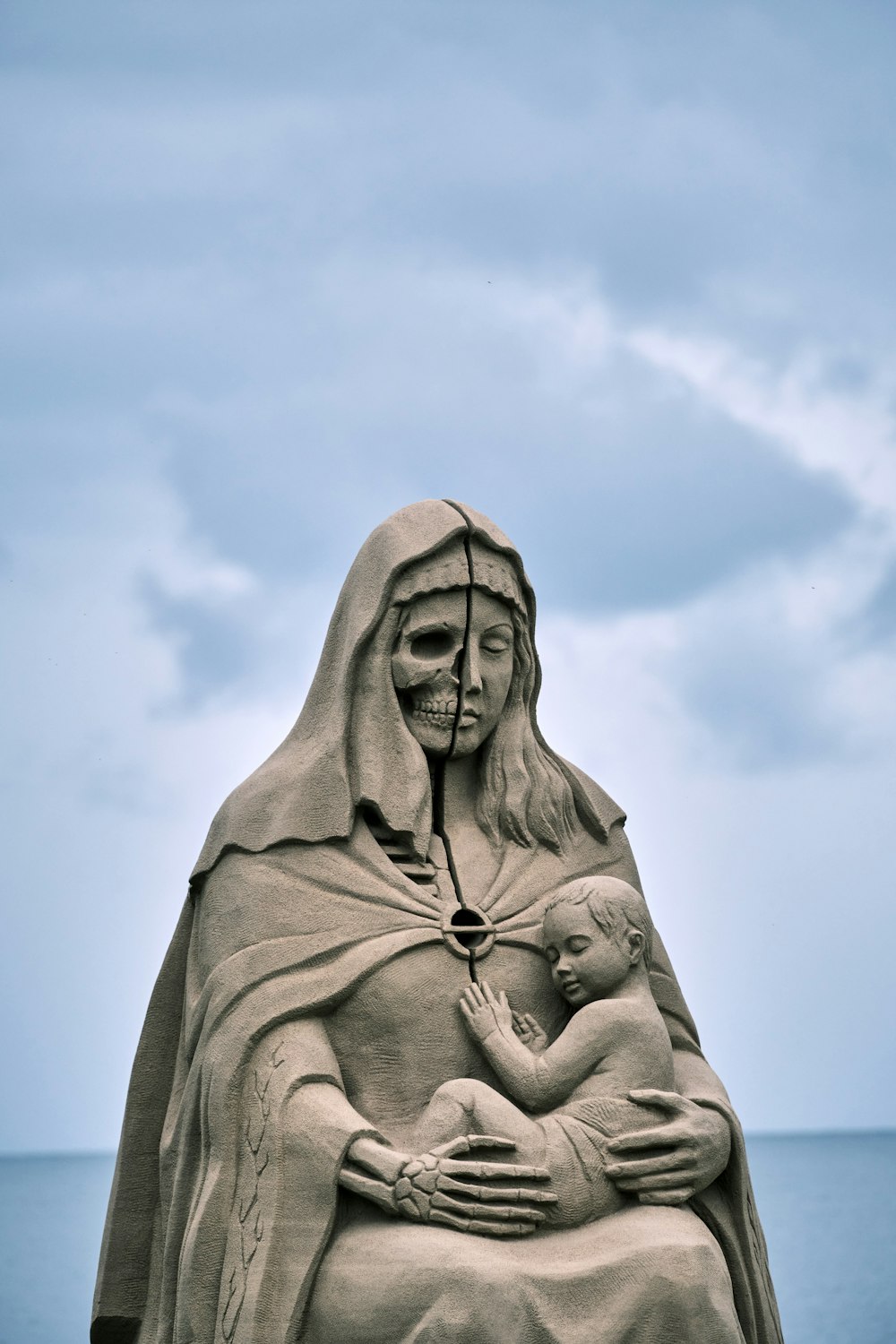 estátua de concreto cinzenta sob o céu azul durante o dia