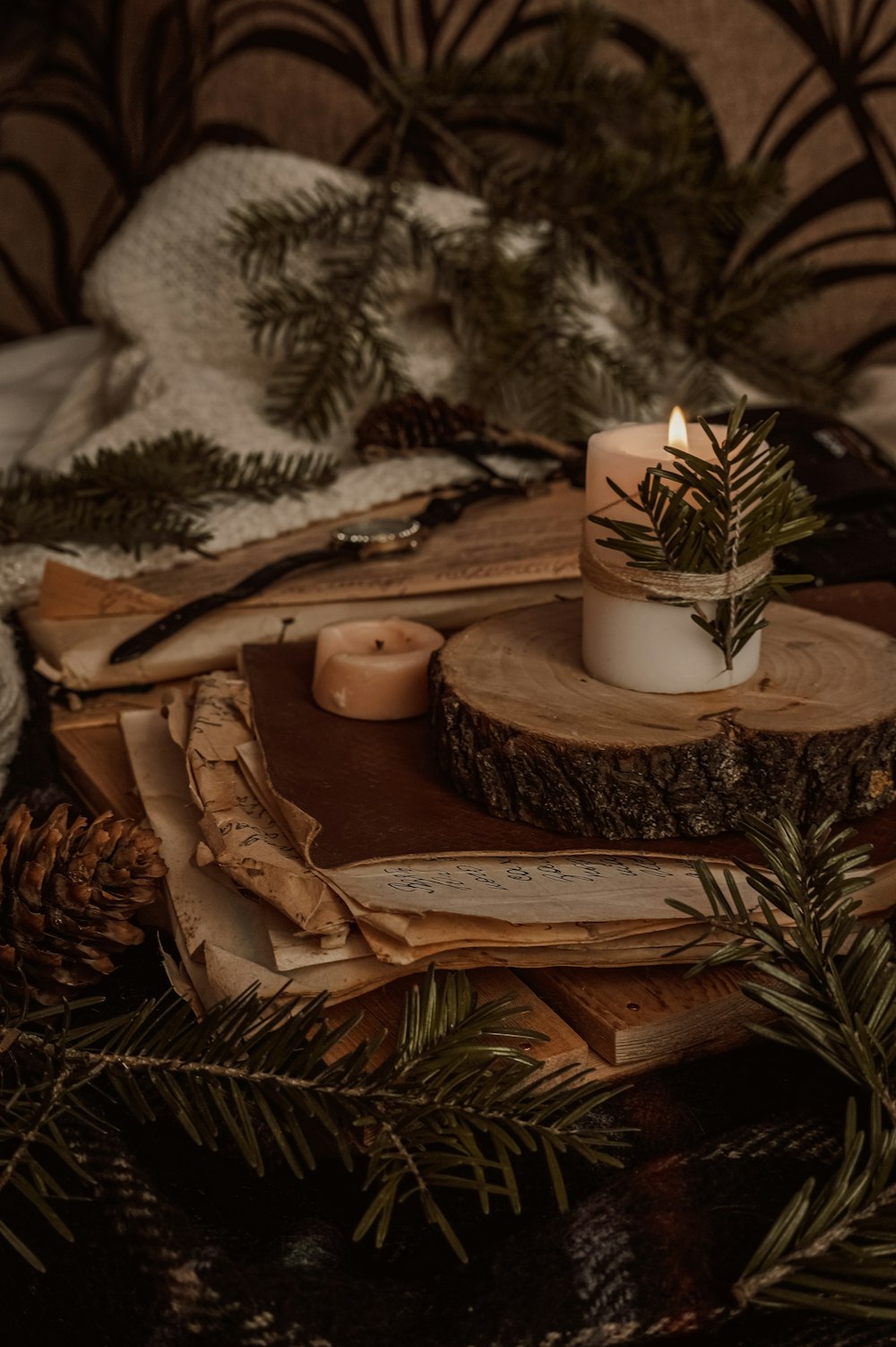 weiße Stumpenkerze auf braunem Holztablett