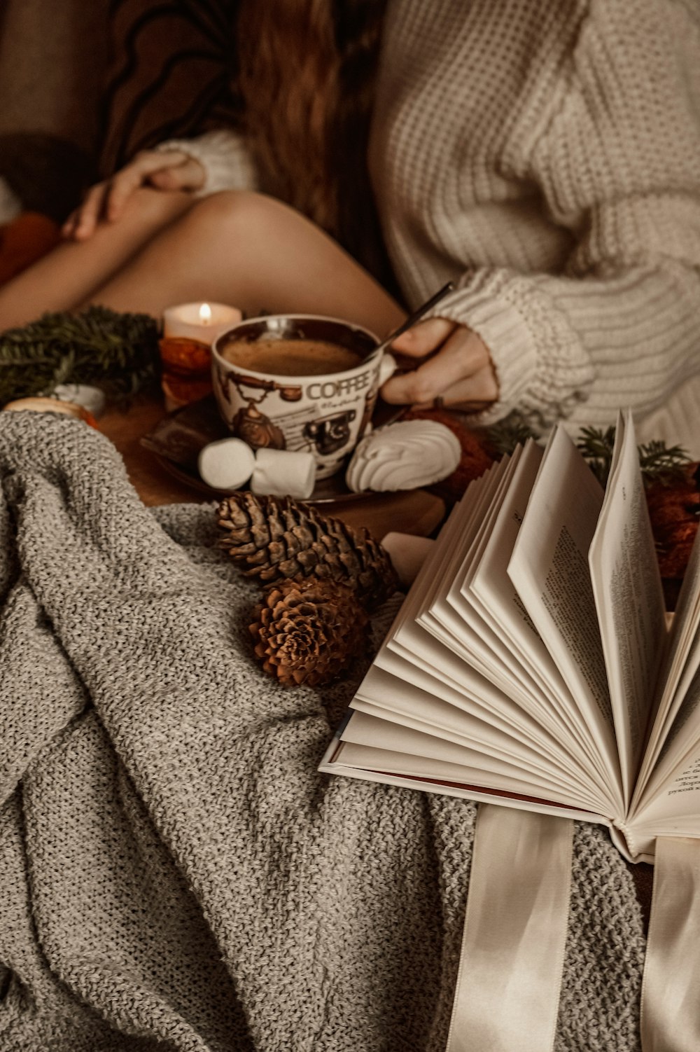 mujer en suéter gris leyendo libro